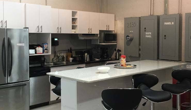 The building's kitchen: a quartz island, a two-door fridge, a microwave and cabinets